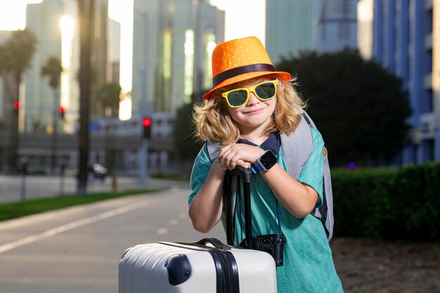 Bambino ragazzo e valigia da viaggio Bambino e bagagli Preparati per il viaggio di un bambino in vacanza Piccolo turista con borsa da viaggio Bambino viaggiatore e bagaglio Bambino con borse per i bagagli che vanno in vacanza