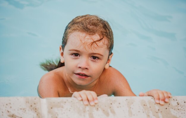 Bambino ragazzo nuotare in piscina durante le vacanze estive