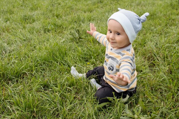 Bambino ragazzo sull'erba in estate Un bambino piccolo in una passeggiata