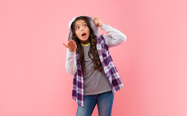 Bambino scioccato con i capelli ricci nel cappuccio. acconciatura di bellezza da hipster per adolescenti. modello di moda casual femminile.