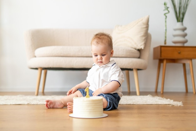 Bambino seduto sul pavimento che gioca con la torta