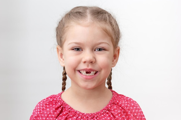 Bambino serio senza denti senza denti superiori su sfondo bianco