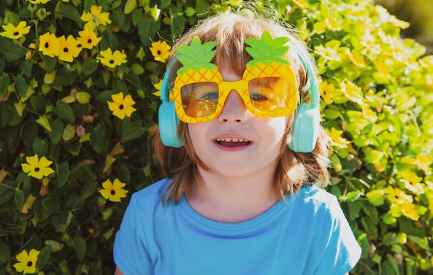 Bambino sorridente con occhiali da sole all'aperto estate bambini tempo ragazzo in pazzi occhiali da sole ananas