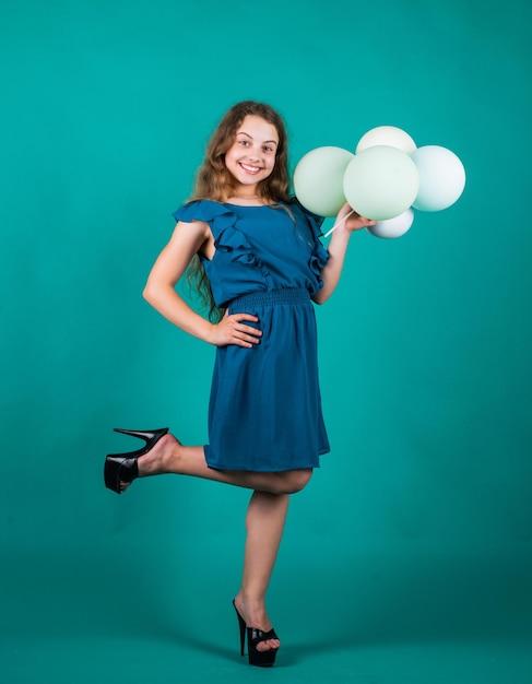 Bambino sorridente con palloncini da festa. felicità dell'infanzia. bella ragazza in abito. bambino moda formale. allegro sognatore a occhi aperti. moda e bellezza. il suo look perfetto per l'acconciatura.