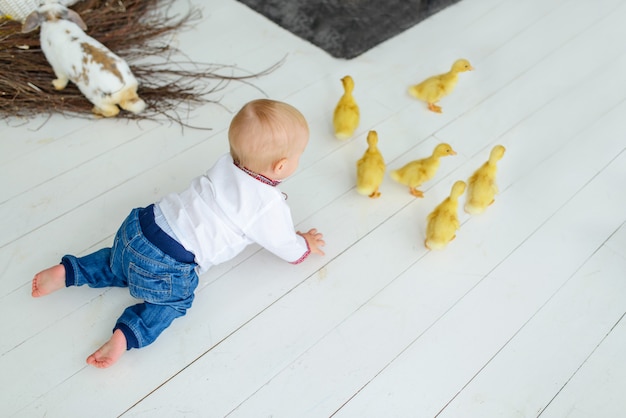 Bambino sorridente sveglio in ricamo tradizionale in decorazioni colorate di Pasqua