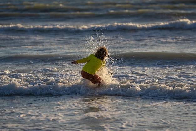 Bambino spensierato che corre sul mare felice bambino carino che corre vicino all'oceano in una calda giornata estiva un ragazzino carino