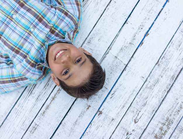 Bambino su fondo di legno bianco