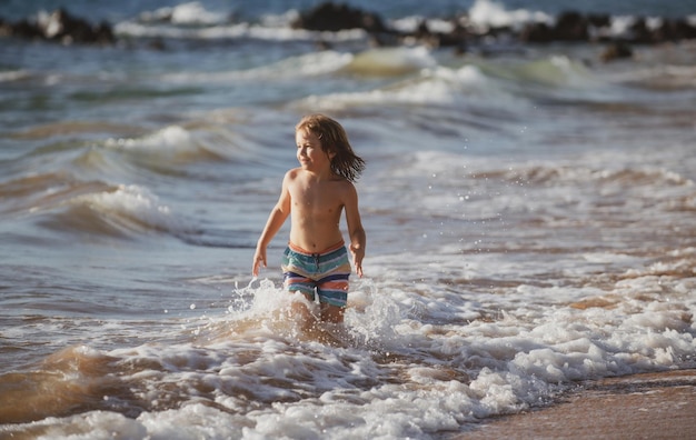 Bambino sulla costa bambino che gioca nell'oceano vacanze al mare il bambino in onde