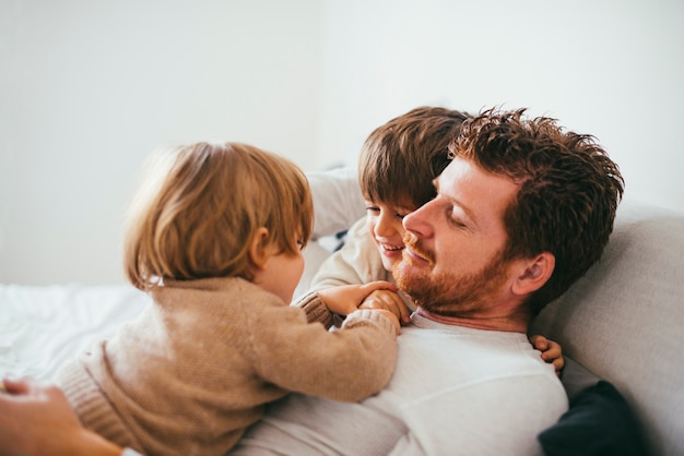 Bambino sulla pancia del padre a casa