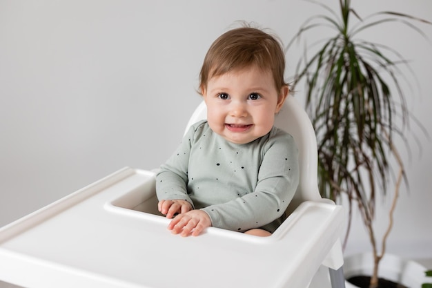 bambino sveglio che si siede nello spazio dell'insegna della carta del seggiolone per testo