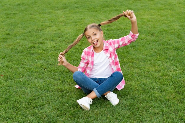 Bambino teenager felice divertendosi sull'erba verde all'aperto