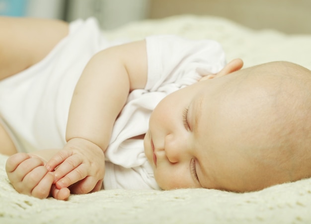 Bambino tranquillo sdraiato su un letto mentre dorme