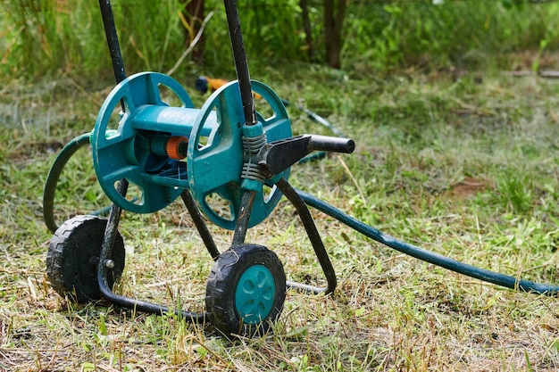 Bambino verde con tubo per irrigazione, attrezzo da giardino compatto