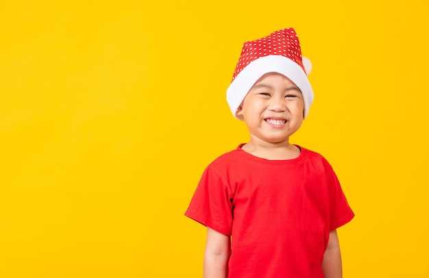 Bambino vestito con un cappello rosso di Babbo Natale Ritratto di un ragazzino asiatico sorridente ed eccitato