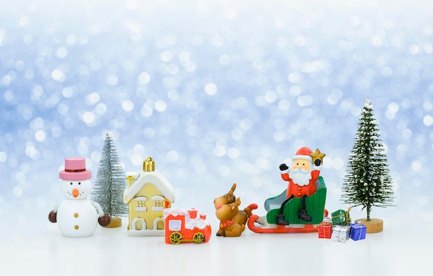 Bambola di Babbo Natale sulla slitta con molte decorazioni di Natale su sfondo di neve