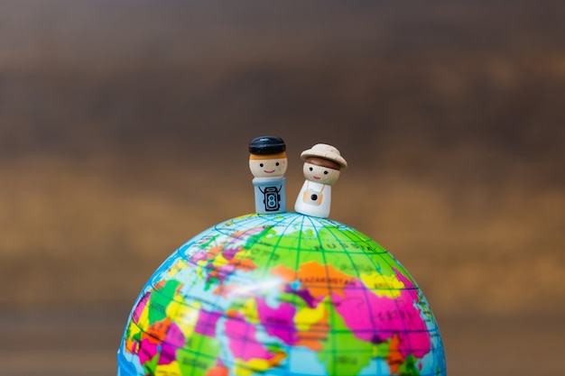 Bambola di legno con il globo su fondo di legno