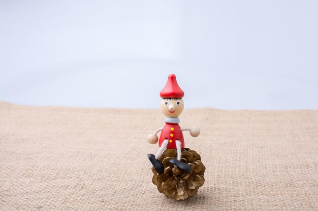 Bambola di legno di Pinocchio che si siede sulla pigna