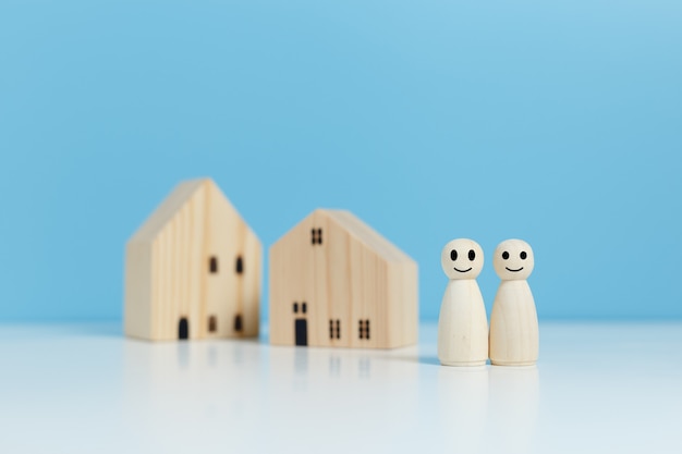 Bambola di legno persone umane con casa, simbolo di relazione di coppia. Assicurazione e investimento immobiliare, risparmio per il futuro e costruzione di una casa, concetto di famiglia per il futuro.