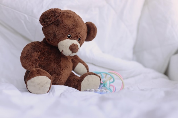 Bambola Teddy Bear con giocattoli colorati nel letto