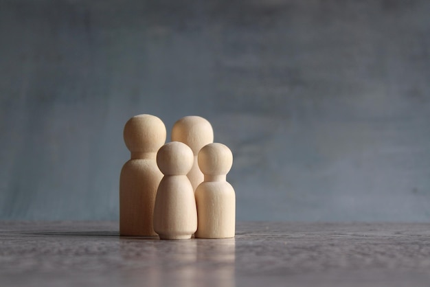 Bambole di legno della famiglia sulla tavola di legno con lo spazio della copia Famiglia concettuale