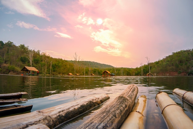 Bambù di rafting sul tramonto della montagna del fiume