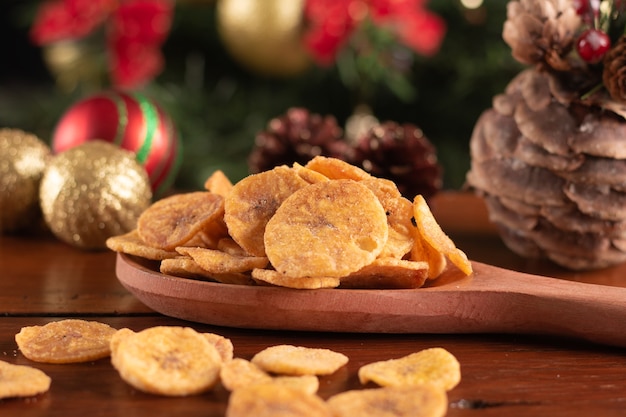 Banana chips nel cucchiaio di legno su uno sfondo di Natale