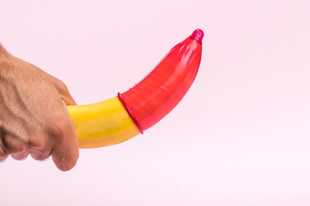 Banana del primo piano con il preservativo rosso su