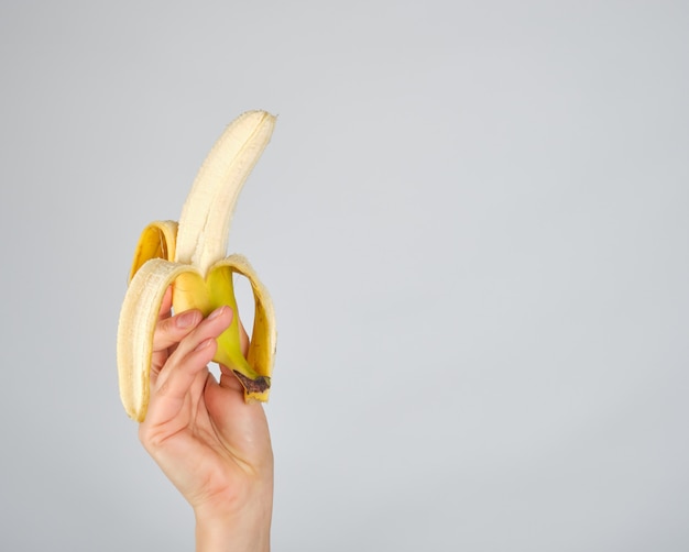 Banana fresca sbucciata in mano femminile