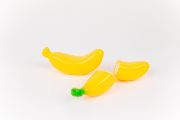 Banana giocattolo di plastica su sfondo bianco