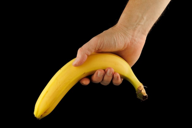 Banana in mano su sfondo nero