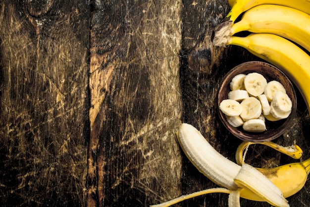 Banana matura affettata in una ciotola. Su un tavolo di legno.