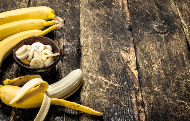 Banana matura affettata in una ciotola. Su uno sfondo di legno.