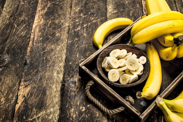 Banana matura affettata in una ciotola. Su uno sfondo di legno.