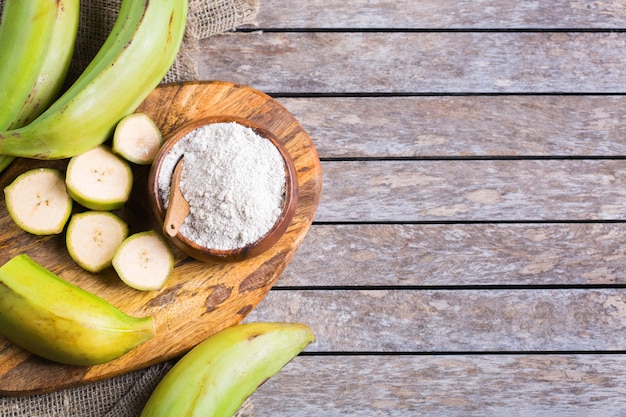 Banana verde, farina di platano su un tavolo. Sfondo piatto vista dall'alto