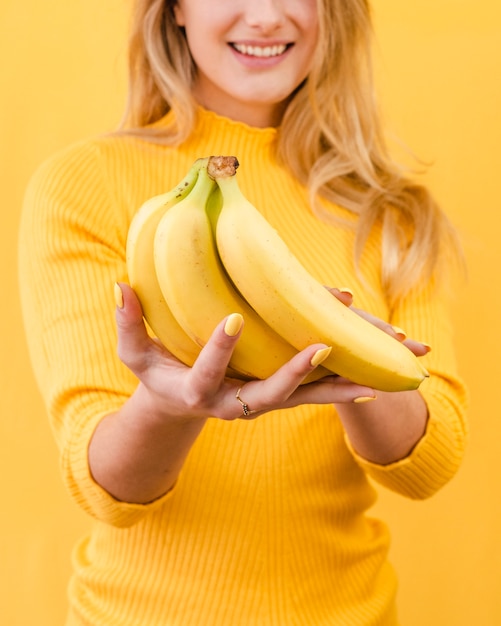 Banane della tenuta della donna del primo piano