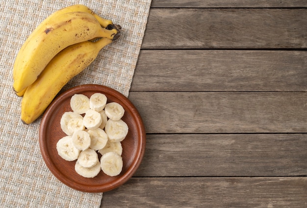 Banane e fette su un tavolo di legno con copia spazio.
