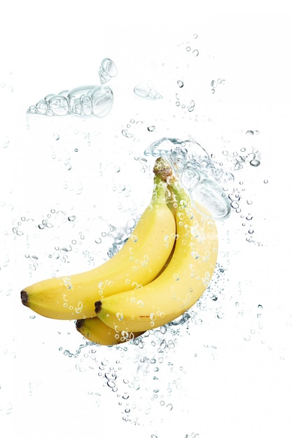 Banane fresche che cadono in acqua