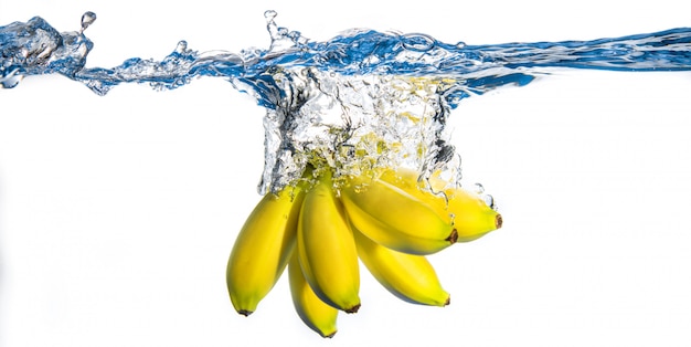 Banane fresche che cadono in acqua