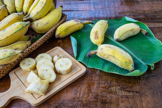 Banane fresche in un cestino su un tavolo di legno