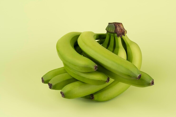 Banane fresche verdi su sfondo verde