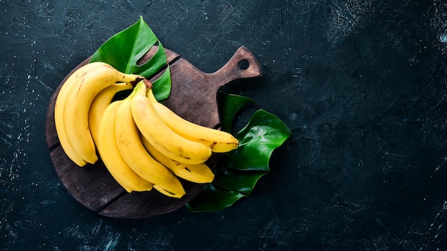 Banane gialle fresche su un tavolo di pietra nero Vista dall'alto Spazio per la copia gratuito