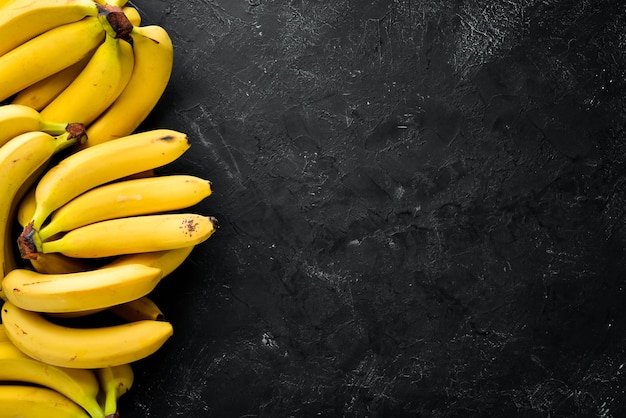 Banane gialle fresche su un tavolo di pietra nero Vista dall'alto Spazio per la copia gratuito