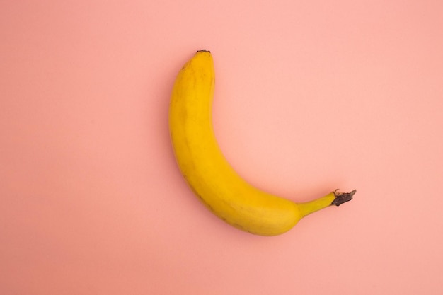 Banane gialle luminose su sfondo rosa