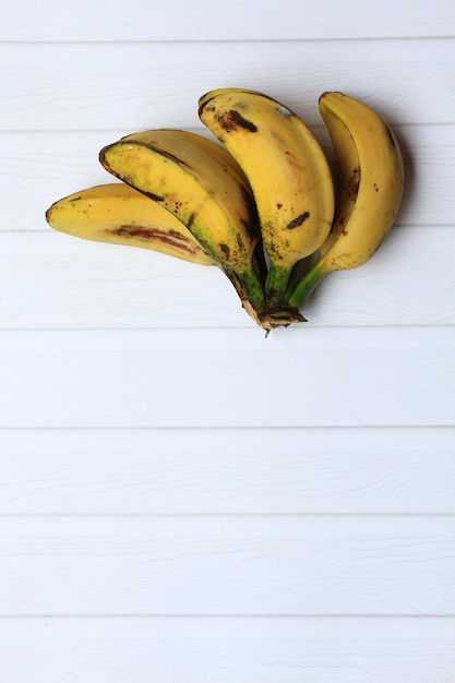 Banane saba mature capovolte su sfondo bianco Composizione a metà