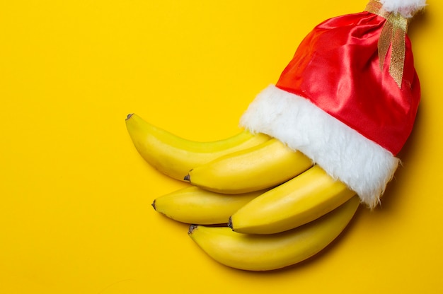 Banane su sfondo giallo in cappello di Babbo Natale