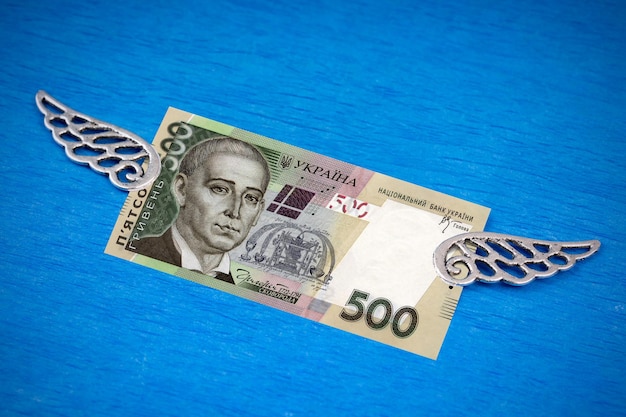 Banconota da 500 grivna ucraina con ali d'argento decorative su sfondo blu