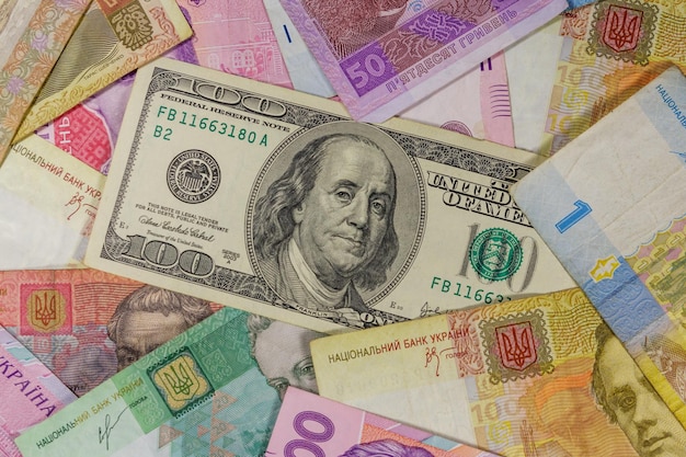 Banconota da cento dollari su uno sfondo di banconote ucraine hryvnia