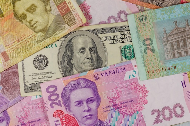 Banconota da cento dollari su uno sfondo di banconote ucraine hryvnia