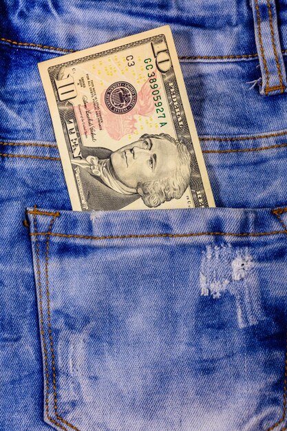 Banconote da dieci dollari americane in una tasca dei jeans blu