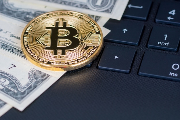 Banconote e bitcoin del dollaro su una tastiera